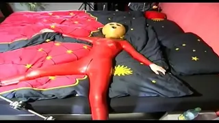 A girl dressed in red latex has a real sinister mask