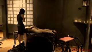 Mistress t. submissive with her paddle in her dungeon