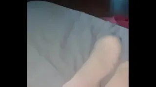 My wife's feet in short socks and shorts in bed