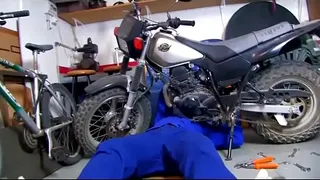 She helps the mechanic giving a blow job