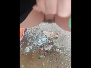 Woman Urges Intensely in Downpour onto Puddle